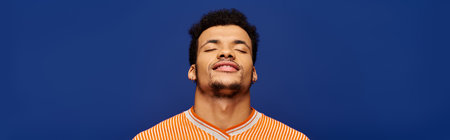 Confident man with a charming smile embraces tranquility in a lively setting.の写真素材