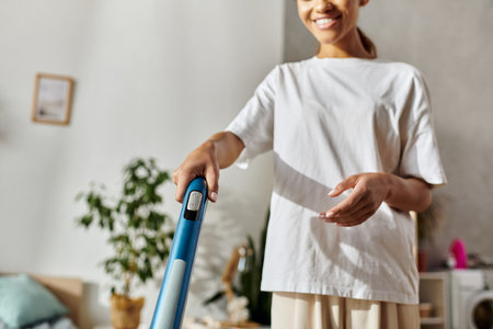 Young woman tidies her modern apartment, enjoying the process of cleaning at homeの写真素材