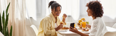 Two young women enjoy breakfast together, celebrating love and connection in a cozy space, bannerの写真素材