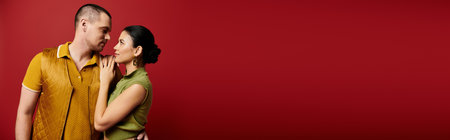 A young couple dressed in fashionable attire share a tender gaze in a studio, celebrating love, bannerの写真素材