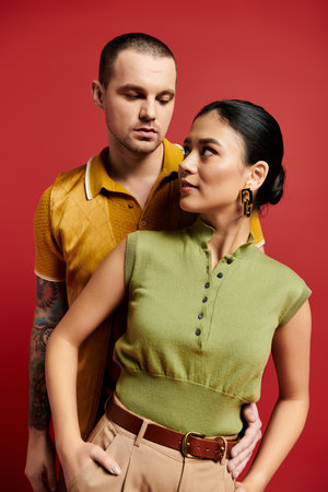 A young couple in trendy outfits expresses their affection in a vibrant studio setting.の写真素材