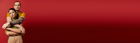 A beautiful couple embraces warmly, showcasing trendy outfits and deep affection for each other, bannerの写真素材