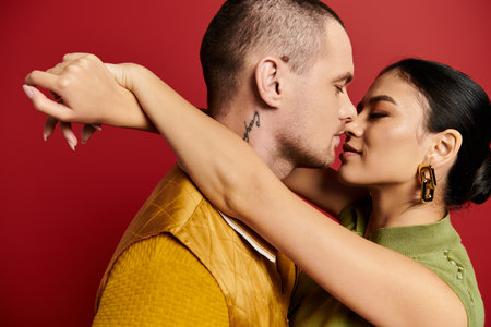 A lovely young couple enjoys an intimate moment in stylish attire against a vibrant backdrop.の写真素材