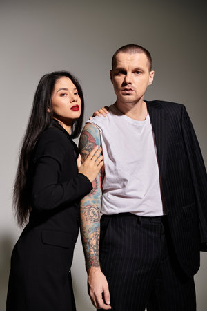 A couple exudes romance in a studio, showcasing stylish attire and deep affection for each other.の写真素材