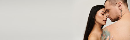 A seductive couple embraces passionately in a studio, radiating romance and warmth, bannerの写真素材