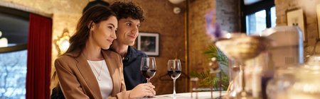 A beautiful couple celebrates their love during a cozy Valentines dinner with glasses of wine, bannerの写真素材