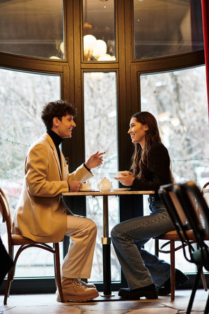 A young couple enjoys a romantic meal while celebrating their love in a charming restaurant.の写真素材