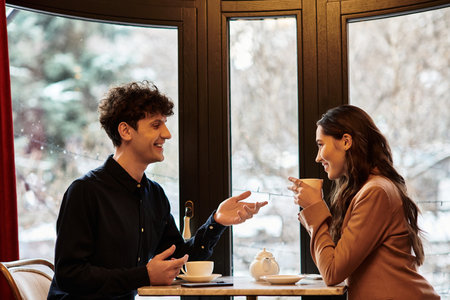 A beautiful couple celebrates their love in a cozy restaurant, enjoying each others company.の写真素材