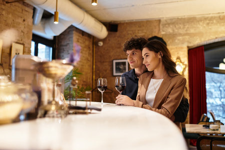 A young couple shares a cozy dinner, savoring wine and each others company.の写真素材