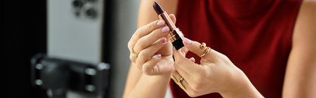 Young woman showcases top beauty product while holding red lipstick, bannerの写真素材