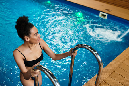 Relaxation takes center stage as a young woman steps into a serene spa pool, embracing peace.