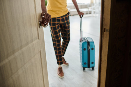 A young african american man prepares to embark on his next adventure while holding a suitcase.の写真素材