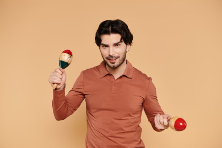 Brightly dressed young man plays with maracas, radiating joy in a warm and inviting environment.の写真素材