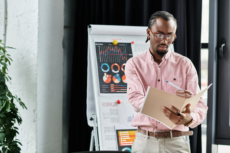 Focused professional takes notes in a stylish workspace filled with vibrant charts and graphs.の写真素材