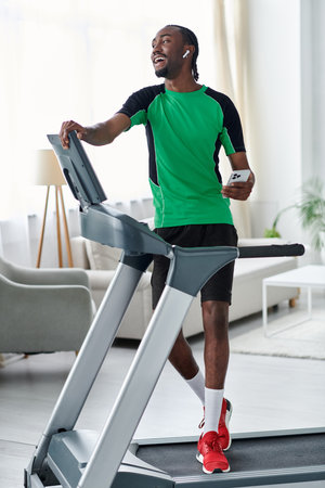 Energetic young man happily using treadmill while listening to music in a bright gym setting.