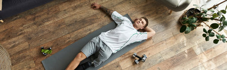 Handsome young man with a prosthetic leg stretches on a mat after an intense workout session.の写真素材