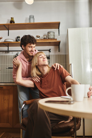 Two men share a tender moment in a welcoming kitchen, radiating love and connection.の写真素材