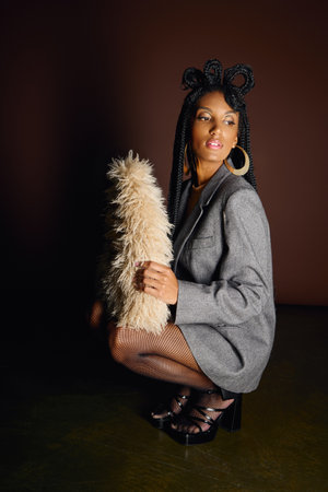 A young woman poses confidently, highlighting her unique fashion sense with strong accessories.の写真素材