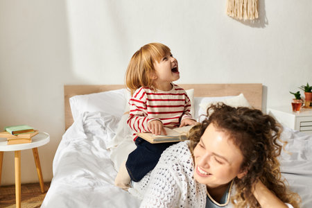Curly mother and daughter bond while reading together in a cozy, modern living space.