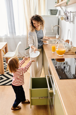 A joyful mother and her daughter share a playful moment in the cozy kitchen preparing for a meal.の写真素材