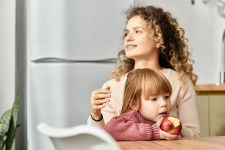 Mother and daughter share a beautiful moment together, embracing the joy of modern parenting.の写真素材