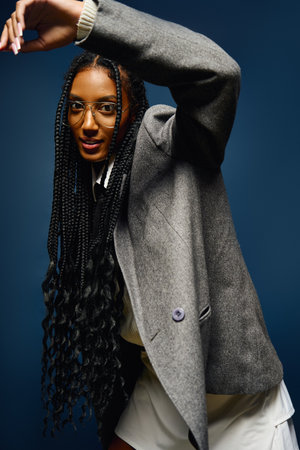 Confident young woman with braids poses elegantly, expressing her artistic side.