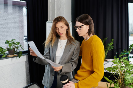 Young individuals engage in a focused discussion while reviewing documents in a stylish workspace.