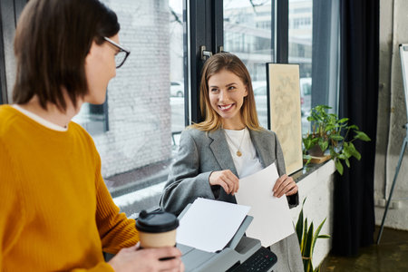 Two young people share ideas during a lively discussion in a modern office.の写真素材