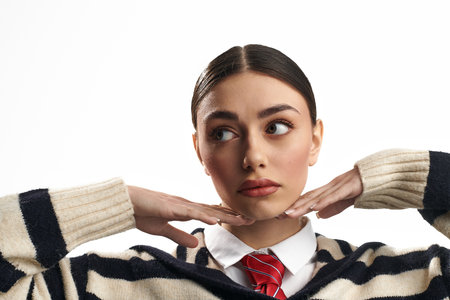 A beautiful young woman shows a thoughtful expression while posing in a stylish outfit.の写真素材