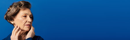 Mature woman showcases her beauty and style in trendy attire with a captivating expression, bannerの写真素材