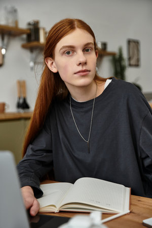Casual reading unfolds as a young man relaxes in his modern apartment with style.