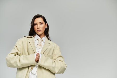 A young woman exudes elegance while wearing a trendy oversized blazer paired with a chic shirt.