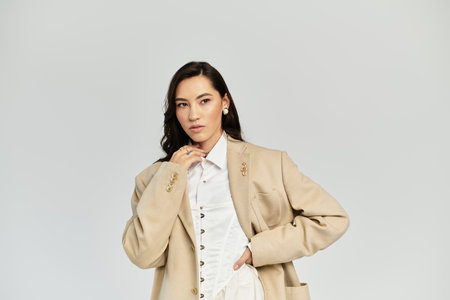 Elegant woman showcases her beauty and style while posing in a chic and modern backdrop.の写真素材