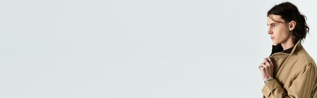 A handsome young man stands thoughtfully, showcasing his trendy outfit and expressive demeanor.の写真素材