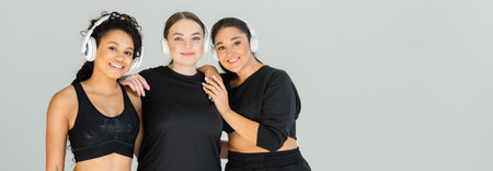 Three confident women celebrate their fitness journey together, showcasing style and strength.の写真素材