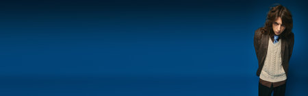 A stylish young man stands confidently, flaunting trendy attire with effortless elegance.のeditorial素材