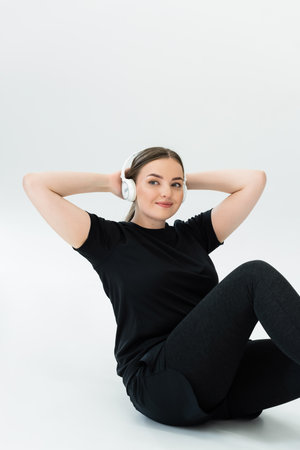 A strong and beautiful woman engages in a fitness routine while smiling, wearing stylish sportswear.のeditorial素材
