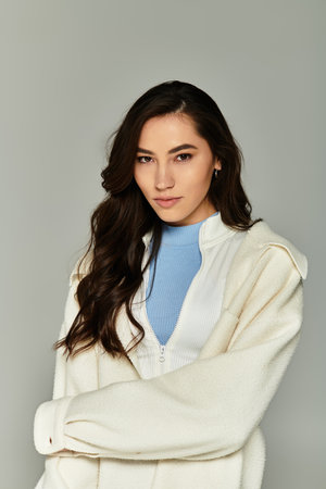 Stylish young woman poses confidently in a chic outfit, showcasing contemporary fashion trends.のeditorial素材