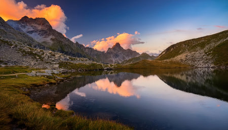 Breathtaking sunset reflections over tranquil alpine lake in summer serenity.の素材
