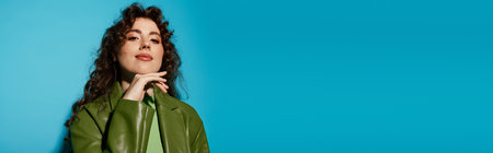 A fashionable young woman showcases her unique style with confidence against a bold blue backdrop.のeditorial素材