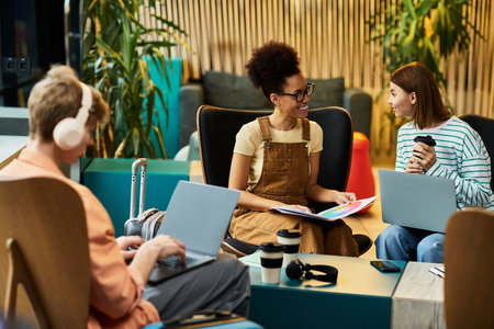 Colleagues engage in a lively discussion and brainstorming session in a hotel lounge area.の写真素材