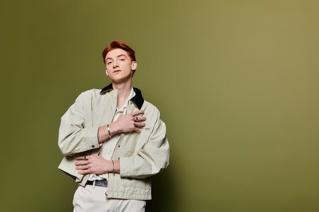 A young man with striking features holds his hand on his heart, conveying deep emotion.のeditorial素材