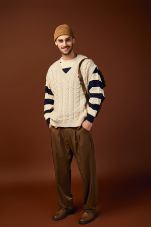 A stylish young man in a beanie poses confidently in a trendy studio.のeditorial素材