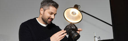 A skilled individual examines camera settings in a stylish studio filled with soft lighting.の写真素材