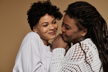 Two fashionable women embrace tenderly, showcasing their love and style with bright smiles.の写真素材