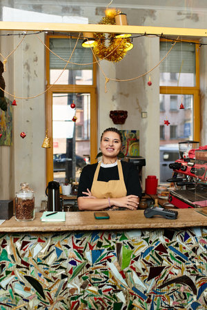 A beautiful young woman stands confidently at the cafe counter, radiating warmth and charm.のeditorial素材
