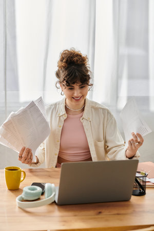 Brightly lit space features a young woman happily organizing her documents while working.のeditorial素材