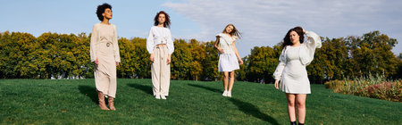 Four stylish women enjoy springs beauty in a scenic park beneath blue skies.
