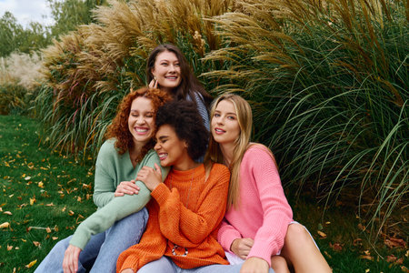 Group of fashionable friends enjoy a sunny day outdoors, showcasing confidence and stylish outfits.の写真素材