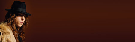 Young, handsome man showcases modern style with a hat, radiating confidence in a cozy atmosphere.のeditorial素材